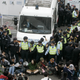 Protesters sit on a road to block the police truck outside the Star Ferry Clock Tower in 2006.